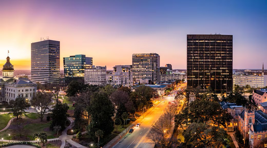The downtown Columbia skyline at dusk, with the South Carolina State House dome lit at left
